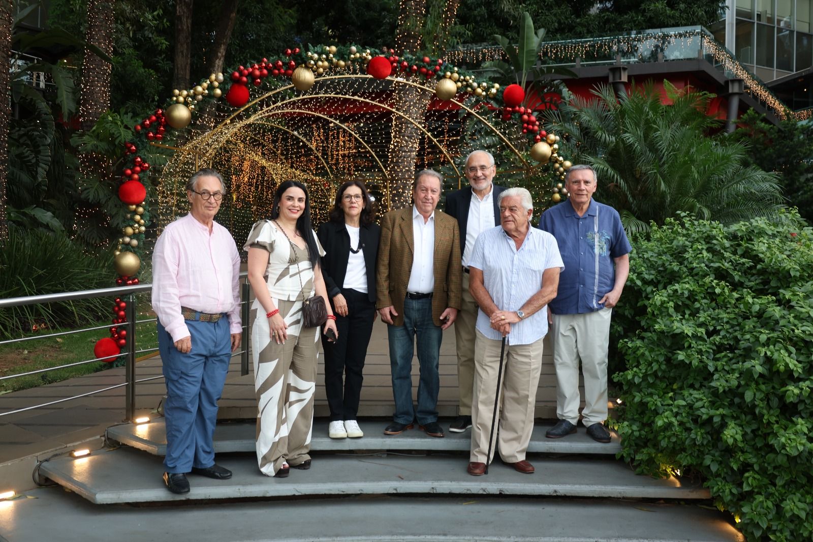 A group of key figures, including Olinda Salguero, President of Fundación Esquipulas, Vice President of Misión Presidencial, and a member of the SSCC Board, pose in front of a beautifully lit festive arch. The gathering highlights camaraderie and collaboration among leaders committed to sustainability and regional progress.